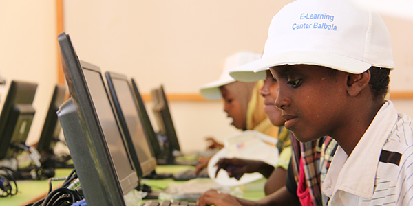 Boy with a cap looking at a computer screen